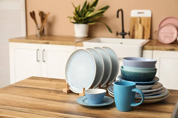 Mutfaktaki ahşap masada temiz mavi tabaklar.