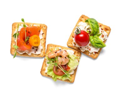 Beyaz arka planda farklı malzemelere sahip lezzetli krakerler, yakın plan.