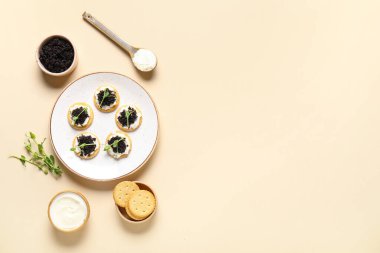 Peynirli krakerler ve bej kaplamalı siyah havyar.