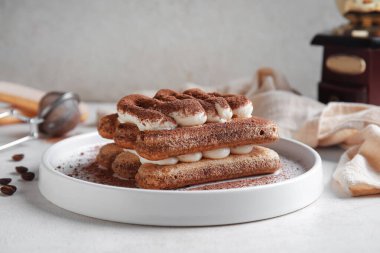 Tatlı tiramisu tabağı ve beyaz arka planda kahve çekirdeği.