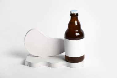 Gri arka planda soğuk bira şişesiyle dekoratif podyumlar
