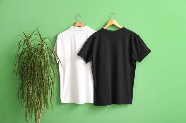 Yeşil arkaplanda asılı şık tişörtler