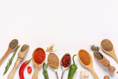 Gri arka planda aromatik baharatlı farklı kaşıklar ve kepçeler