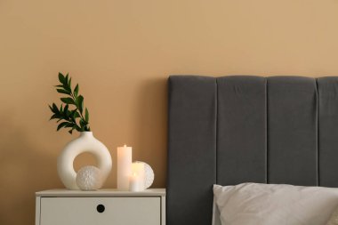 Yatak odasında yanan mumlar olan komodinin yanında. Yakın çekim.