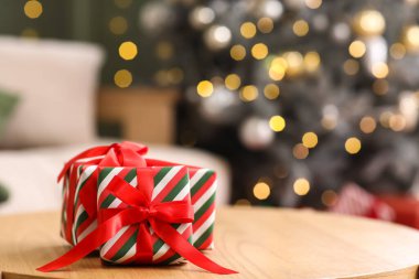 Noel hediyeleri masada bulanık Noel ağacına karşı oturma odasında, yakın plan.