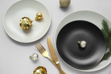 Gri arka planda Noel topları ve köknar dallarıyla güzel bir masa.