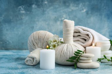 Renkli grunge arkaplan üzerinde yanan mumlar ve çiçekler olan spa kompozisyonu