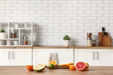 Kesme tahtası ve lezzetli narenciye meyveleri mutfaktaki masada.