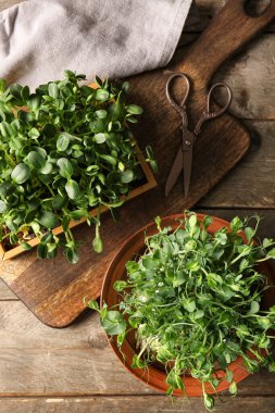 Taze mikro yeşil lahanalar, makas ve tahta arka planda kesim tahtasıyla kompozisyon