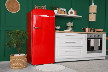 Beyaz tezgah, çatal bıçak ve modern buzdolabı olan şık bir mutfak.