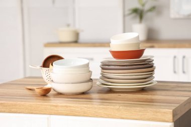 Mutfaktaki ahşap masada farklı tabak ve kaseler.