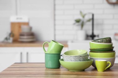 Mutfaktaki ahşap masada çanaklar ve fincanlar.