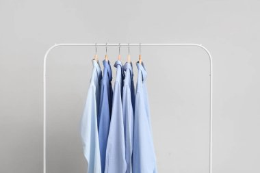 Gri arkaplanda şık mavi yakalı gömlekler.