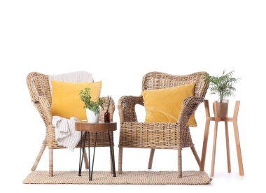 Masalı ve beyaz arka planda bitkileri olan hasır koltuklar