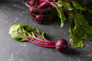 Siyah arka planda taze pancar kökleri olan sepet.