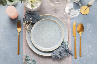 Düğünümüz için güzel bir masa, çingene çiçekleri ve mavi arka planda bir mum.