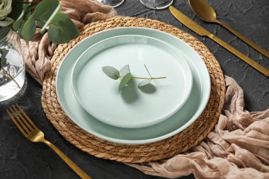 Siyah arka planda okaliptüs dallarıyla düğün için güzel bir masa. Yakın plan.