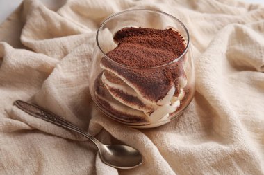Bej kumaş arka planda tatlı tiramisu ile cam