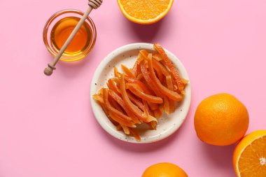 Tatlı portakal şekeri tabağı, taze meyve ve bal pembe arka planda, üst manzara