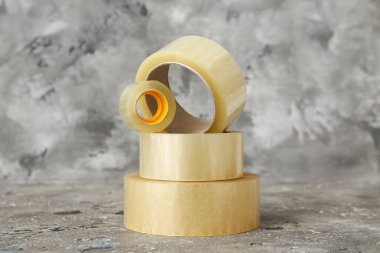 Gri arkaplanda farklı yapışkan bant ruloları