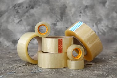 Gri arkaplanda farklı yapışkan bant ruloları