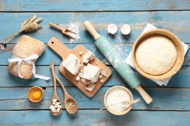 Taze maya, hamur, bir kase un, yumurta, buğday kulağı ve ahşap zemin üzerinde ekmek.