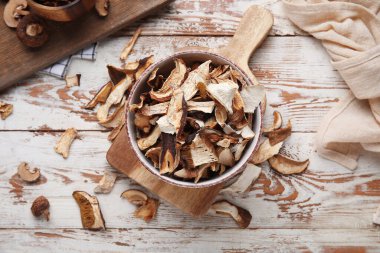 Ahşap arka planda lezzetli kurutulmuş mantarlı kase.