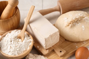 Taze maya, hamur, yumurta, bir kase un ve beyaz fayans zemininde merdane.