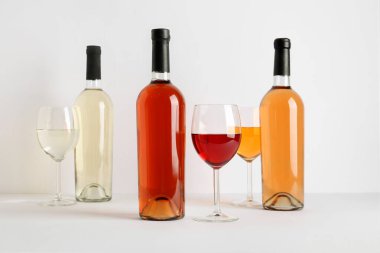 Beyaz arka planda farklı şarap şişe ve bardaklar