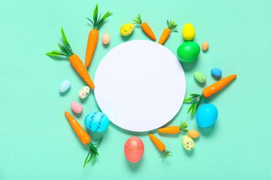 Paskalya yumurtalı boş kart ve turkuaz arka planda dekoratif havuç.