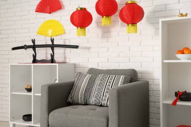 Çin Yeni Yılı için dekore edilmiş oturma odasının içi koltuk ve raf üniteleriyle dolu.