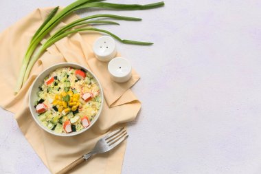 Beyaz arka planda bir kase salata, mısır ve salatalık.