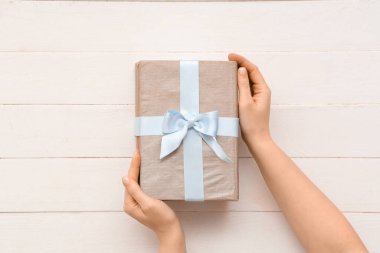 Beyaz ahşap zemin üzerine kitap yığını olan kadın eller