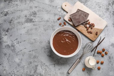 Lezzetli sıcak çikolatalı kase, çırpılmış çırpılmış süt ve grunge grisi arka planda kavanoz. Üst görünüm