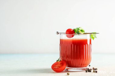 Kerevizli, domatesli ve hafif arkaplanlı bir bardak Bloody Mary.
