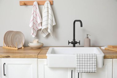 Mutfakta lavabo, mutfak gereçleri ve temiz havlular var.