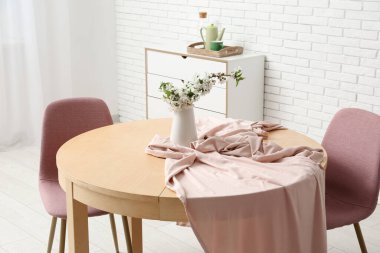 Yemek odasının içindeki beyaz tuğla duvarın yanındaki masa ve sandalyeler, yakın plan.