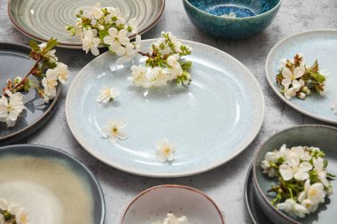 Gri arkaplanda çiçek açan dalları olan farklı temiz tabakalar, yakın plan