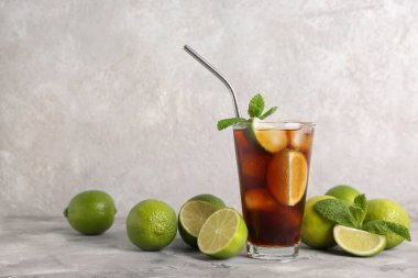 Gri arka planda naneli ve limonlu soğuk Küba Libre kokteyli.