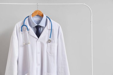 Doktor üniforması ve arka planda steteskop.