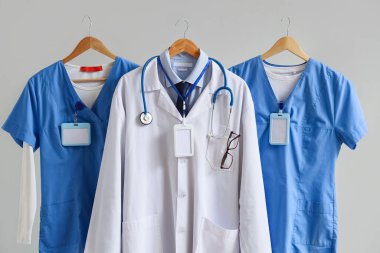 Different medical uniform with badges on light background
