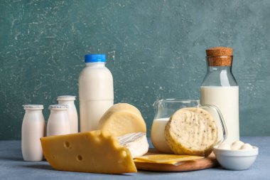 Mavi grunge arka planında yumurtaları olan farklı süt ürünleri.