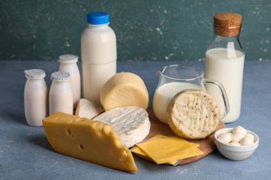 Mavi grunge arka planında yumurtaları olan farklı süt ürünleri.