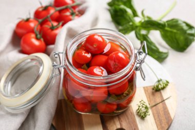 Beyaz grunge arka planda konserve domates, fesleğen ve peçete dolu ahşap tahta tahta.