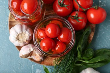 Kavanozlar dolusu fesleğenli, dereotlu ve turkuaz renginde sarımsaklı domates.