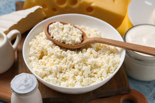 Mavi grunge arka planında mayalanmış süt peyniri olan kase, yakın plan.