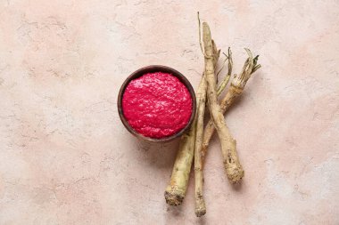 Bej renginde pancar arkaplanlı bir kase yaban turpu sosu.