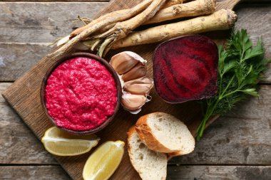 Tahta arka planda pancar, ekmek ve limonlu yaban turpu sosu.