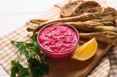 Bir kase yaban turpu sosu, pancar, maydanoz ve limonlu peçete, yakın plan.