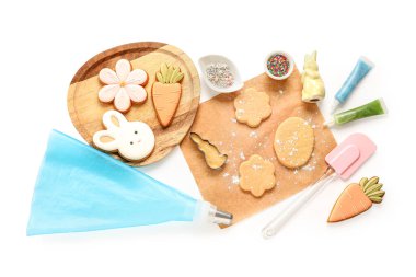 Paskalya kurabiyeli taze hamur, boru torbası ve beyaz arka planda mutfak aletleri.